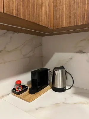 a coffee maker sitting on a wooden tray next to a microwave at Anfa Place, Art Deco Luxury Apartment, Sunny Ocean View in Casablanca