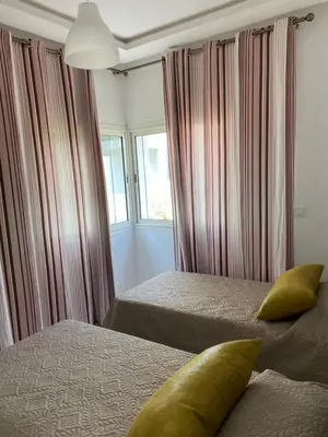 a bedroom with two beds and a window at Lovely 4-bedroom condo with pool in Rabat