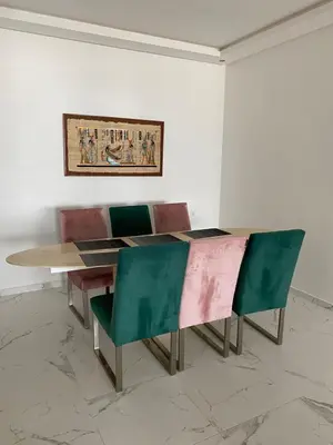 a dining room table with chairs and a painting on the wall at Lovely 4-bedroom condo with pool in Rabat