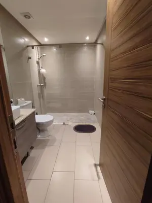 a bathroom with a shower and a toilet and a door at LUXURY 3 bedroom apartment with pool, Nouaceur, Morocco in Derroua