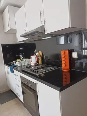 a kitchen with white cabinets and a stove top oven at La Gironde - Sweet Home - Casablanca in Casablanca