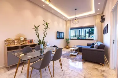 a living room with a glass table and chairs at Airport Apartment Suite Casablanca FREE WIFI Modern Confort Calme in Derroua