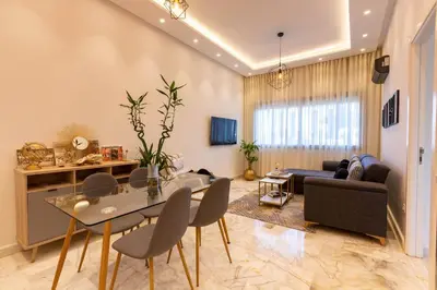 a living room with a table and chairs and a couch at Airport Apartment Suite Casablanca FREE WIFI Modern Confort Calme in Derroua