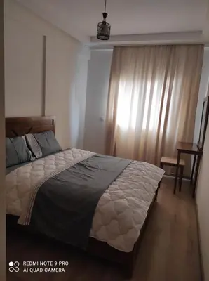 a bedroom with a large bed and a table at Apartment place italie in Rabat