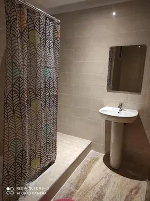 a bathroom with a shower curtain and a sink at Apartment place italie in Rabat