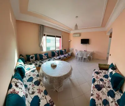 a living room with a couch and a table at Bel Appartement au cœur de BOUZNIKA in Bouznika