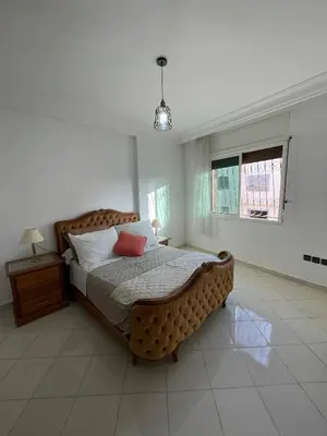 a bedroom with a large bed and a window at Bel Appartement au cœur de BOUZNIKA in Bouznika