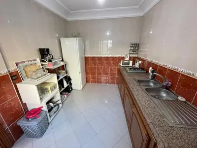 a kitchen with a sink and a refrigerator at Bel Appartement au cœur de BOUZNIKA in Bouznika