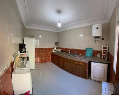 a kitchen with a sink and a refrigerator at Bel Appartement au cœur de BOUZNIKA in Bouznika