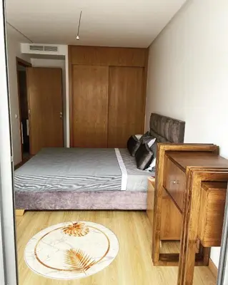 a bedroom with a bed with a wooden wall at Appartement haut standing au quartier les princesses avec grande terrasse et parking gratuit in Casablanca