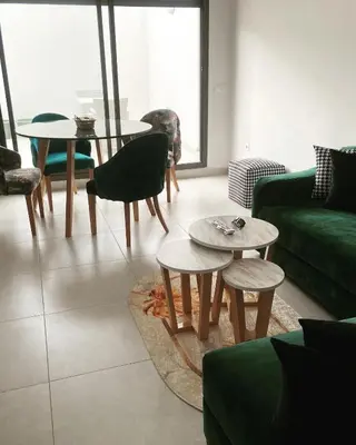a living room with a green couch and tables at Appartement haut standing au quartier les princesses avec grande terrasse et parking gratuit in Casablanca