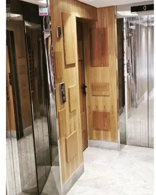 a hallway with wooden doors in a building at Appartement haut standing au quartier les princesses avec grande terrasse et parking gratuit in Casablanca