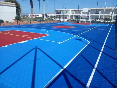 a blue basketball court with a basketball hoop at Appartement à louer dans une résidence balnéaire 3 piscines - RAMOFLORES Sidi Rahal in Sidi Rahal