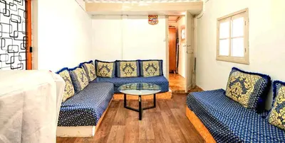 a living room with blue couches and a table at Charmante Maison vue sur mer à Mohammédia plage Manesmane ! in Mohammedia