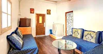 a living room with a blue couch and a glass table at Charmante Maison vue sur mer à Mohammédia plage Manesmane ! in Mohammedia