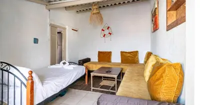 a living room with a bed and a table at Charmante Maison vue sur mer à Mohammédia plage Manesmane ! in Mohammedia