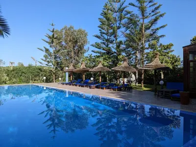 a swimming pool with chairs and umbrellas at Mesdunes in Azemmour