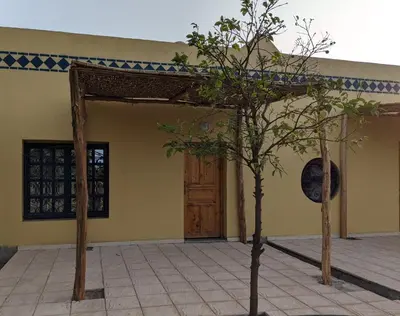 two trees in front of a building with a door at Mesdunes in Azemmour