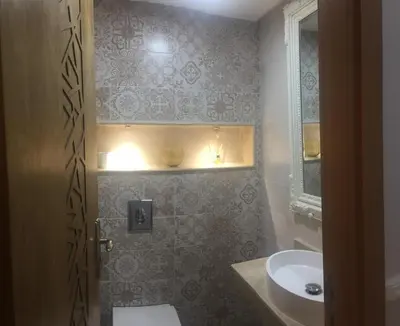 a bathroom with a sink and a toilet and a mirror at Aryam Room in Rabat