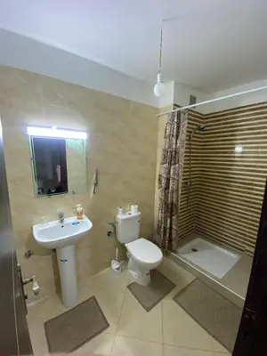 a bathroom with a toilet and a sink and a shower at Magnifique Appartement avec Piscine à Tamaris in Tamaris