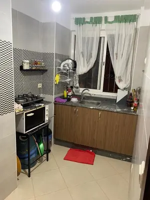 a kitchen with a sink and a stove and a window at Magnifique Appartement avec Piscine à Tamaris in Tamaris