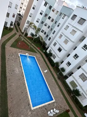 an empty swimming pool in front of a building at Magnifique Appartement avec Piscine à Tamaris in Tamaris
