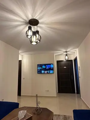 a living room with a table and a chandelier at Magnifique Appartement avec Piscine à Tamaris in Tamaris