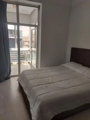 a bedroom with a bed and a large window at Gauthier confort in Casablanca