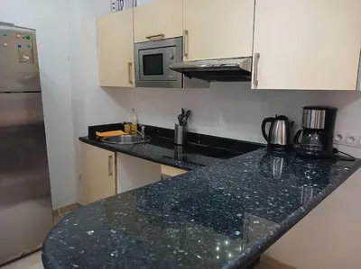 a kitchen with a black counter top and a microwave at Gauthier confort in Casablanca