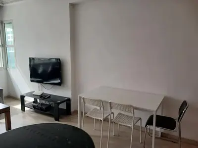 a living room with a table and chairs and a tv at Gauthier confort in Casablanca