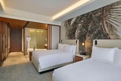 a hotel room with two beds and a painting on the wall at Conrad Rabat Arzana in Rabat