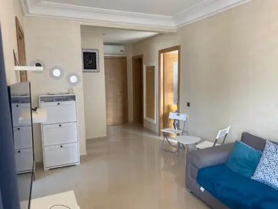 a living room with a couch and a table at Appartement blanca beach Sidi Rahal accès direct à la plage in Casablanca