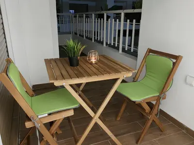 a wooden table and two chairs on a balcony at Central Park House - 70m² in Mohammedia
