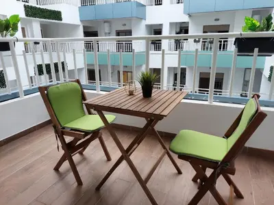 a wooden table and two chairs on a balcony at Central Park House - 70m² in Mohammedia