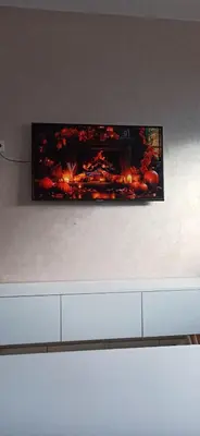 a tv hanging on a wall with a painting on it at La Perle in Casablanca