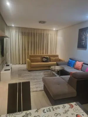 a living room with two couches and a television at Joli appartement à Harhoura in Oulad Kerroum