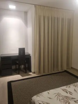 a bedroom with a desk and a bed and a window at Joli appartement à Harhoura in Oulad Kerroum