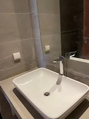 a white sink in a bathroom with a mirror at Joli appartement à Harhoura in Oulad Kerroum
