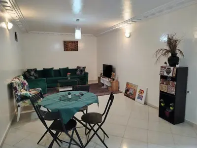 a living room with a green couch and a table at Appartement 11 Casa Voyageurs in Casablanca