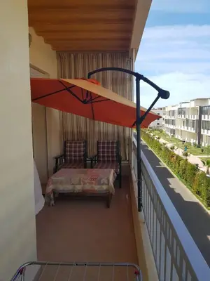 a balcony with a bed and an umbrella at Beach-Side 2-BR Oasis with Private Pool & Parking in Casablanca