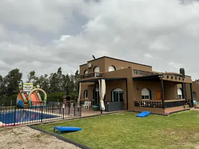 a building with a playground in a park at American Farm Villa Grand Casablanca/El Jadida in Zaouia Sidi Bou Azza