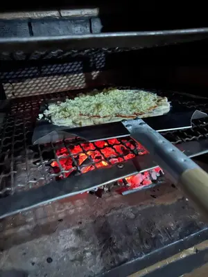 two pizzas and vegetables cooking on a grill at American Farm Villa Grand Casablanca/El Jadida in Zaouia Sidi Bou Azza