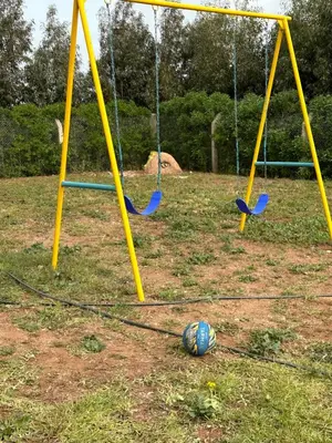 two swings in a park with a ball on the ground at American Farm Villa Grand Casablanca/El Jadida in Zaouia Sidi Bou Azza