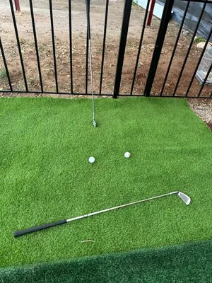 a golf club and two balls on the grass at American Farm Villa Grand Casablanca/El Jadida in Zaouia Sidi Bou Azza