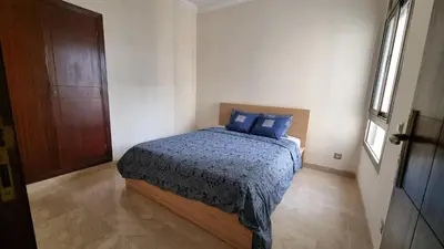 a bedroom with a bed with blue pillows on it at My Cosy Place Rabat - Skhirat 2min de la plage avec Piscine in Skhirat