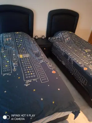 two beds in a bedroom with a bedspread with an astronomy at Belfakih in Beni Brour