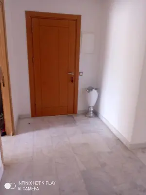 an empty room with a door and a vase on the floor at Belfakih in Beni Brour