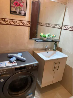 a bathroom with a washing machine and a sink at Magnifique appartement proche Arribat Center in Rabat