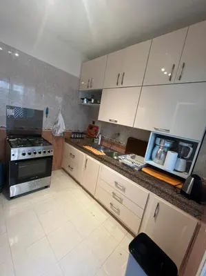 a kitchen with white cabinets and a stove top oven at Magnifique appartement proche Arribat Center in Rabat