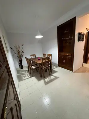 a dining room with a wooden table and chairs at Magnifique appartement proche Arribat Center in Rabat